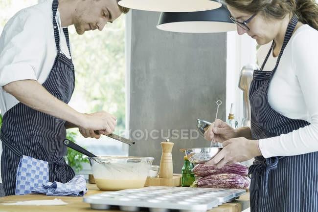 Dos chefs preparando comida en la mesa - foto de stock