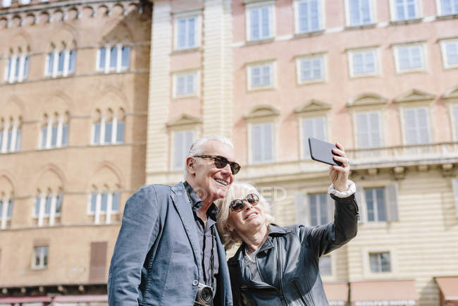 Pareja de turistas tomando selfie en la ciudad, Siena, Toscana, Italia - foto de stock