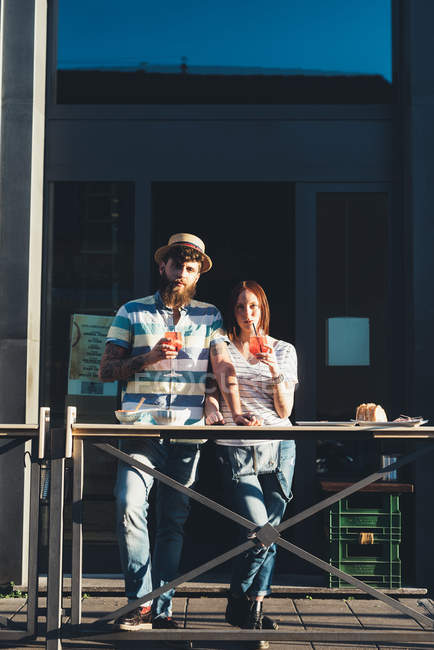 Портрет пары пьющей коктейли в кафе на тротуаре — стоковое фото