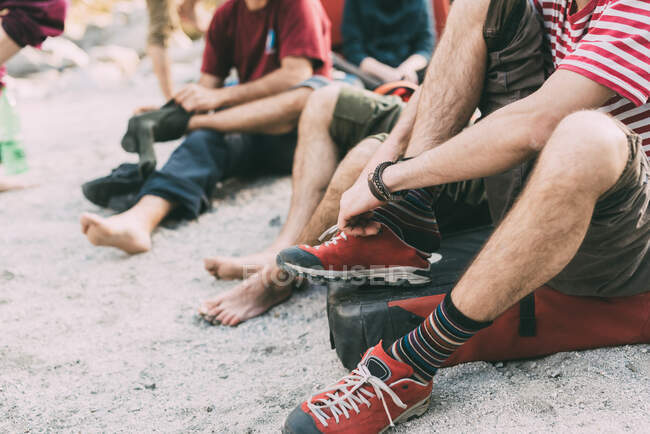 Neck down view of adult bouldering friends putting on socks and trainers, Lombardy, Italy — Stock Photo