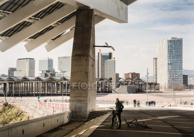 Ciclista feminina olhando para fora do Fórum, Barcelona, Espanha — Fotografia de Stock