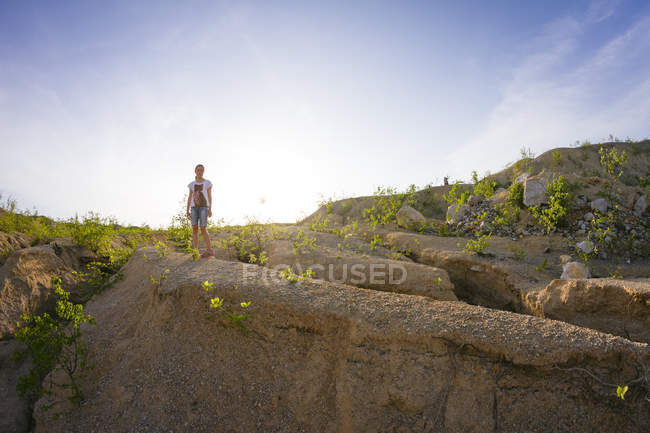 Visão distante da menina adolescente na pedreira contra o céu azul — Fotografia de Stock