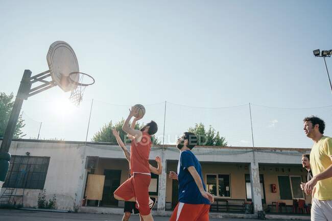 Друзья на баскетбольной площадке играют в баскетбол — стоковое фото