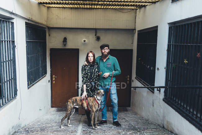 Retrato de pareja genial con perro apartamento al aire libre - foto de stock