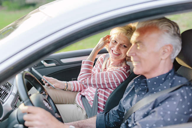 Happy tourist couple driving car — Stock Photo
