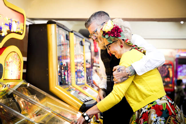 Couple enjoying themselves in amusement arcade, Bournemouth, England — Stock Photo