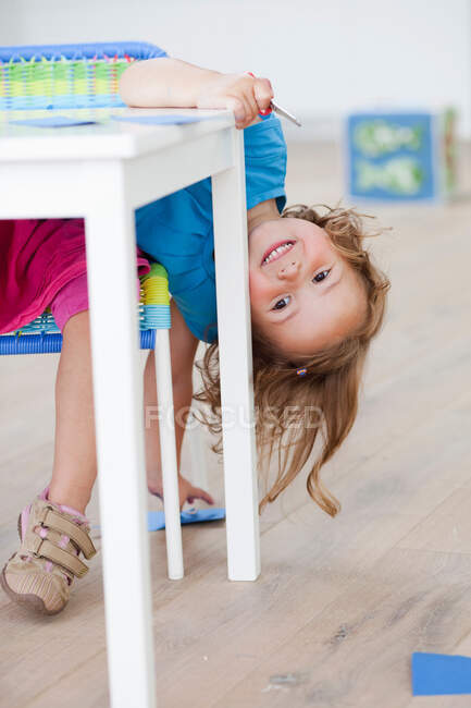 Молодая девушка играет за столом — стоковое фото