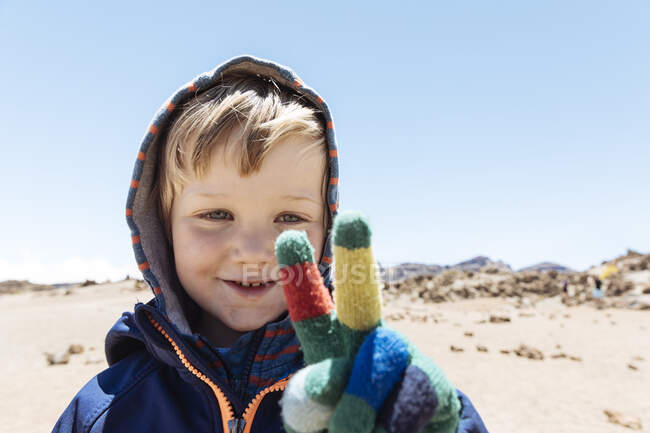Retrato de menino bonito fazendo sinal de paz com a mão enluvada no Monte Teide, Tenerife, Ilhas Canárias — Fotografia de Stock