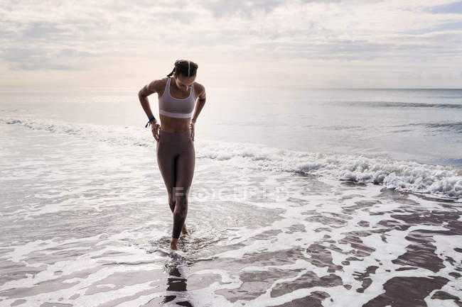 Молода жінка ходить на морському березі — стокове фото