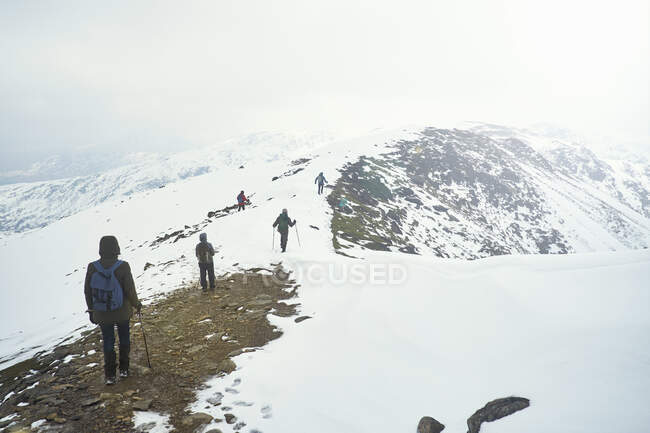 Caminhantes na montanha coberta de neve, Coniston, Cumbria, Reino Unido — Fotografia de Stock