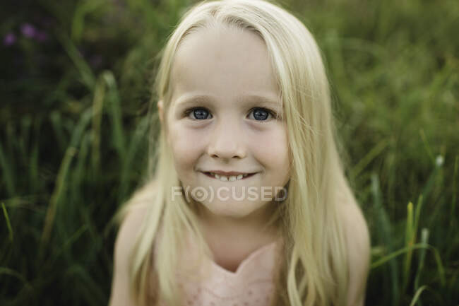 Portrait de fille blonde aux cheveux regardant la caméra souriante — Photo de stock