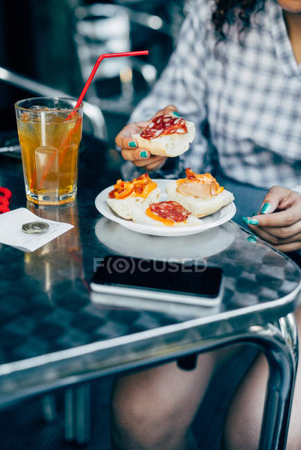 Mujer comiendo en la cafetería de la acera, Milán, Italia - foto de stock