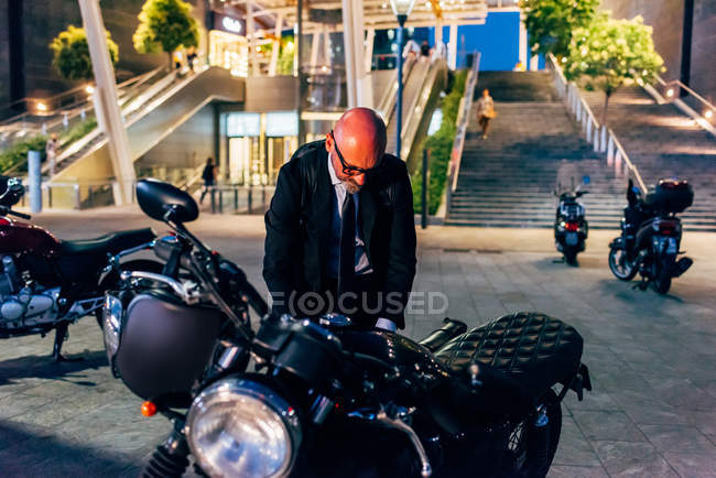 Homem de negócios maduro se preparando para andar de moto — Fotografia de Stock