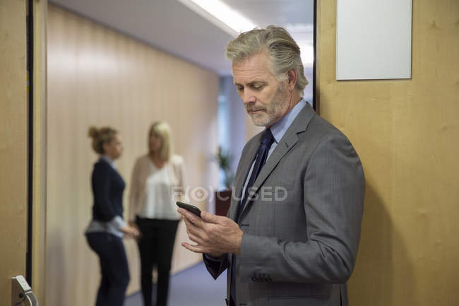 Homme d'affaires mature utilisant un smartphone au bureau — Photo de stock