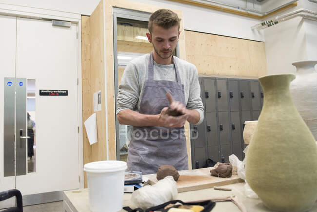 Man in art studio shaping clay — Stock Photo