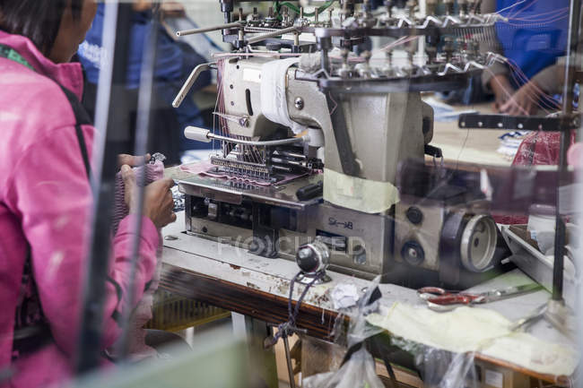 Costurera que trabaja en la máquina de coser de smocking industrial en la fábrica, Ciudad del Cabo, Sudáfrica - foto de stock