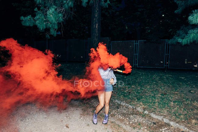 Жінка тримає полум'я в парку вночі — стокове фото