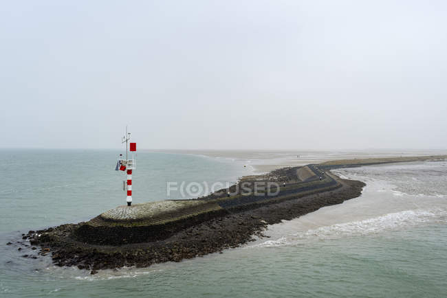 Muelle grande que protege el puerto de la corriente fuerte, West-Terschelling, Frisia, Países Bajos, Europa - foto de stock