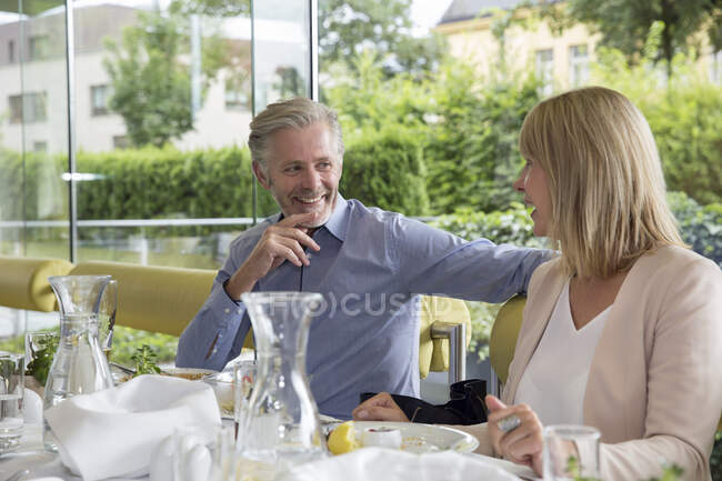 Улыбающаяся пара на свежем воздухе в ресторане — стоковое фото