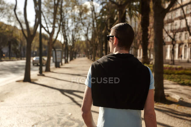 Man walking on tree-lined street, Lisbon, Portugal — Stock Photo