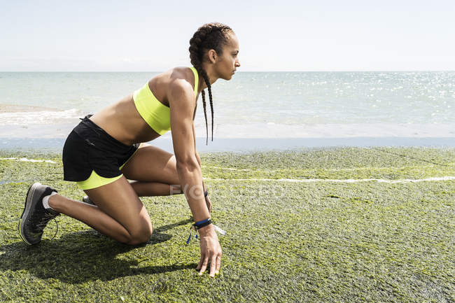 Молодая женщина в спортивной одежде против моря — стоковое фото