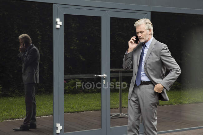 Empresário fazendo conversa telefônica no smartphone — Fotografia de Stock