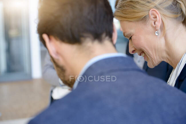 Geschäftsfrau und Mann blicken im Büro-Atrium nach unten — Stockfoto