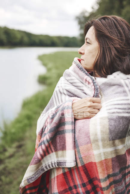 Mulher madura envolta em cobertor em ambiente rural — Fotografia de Stock