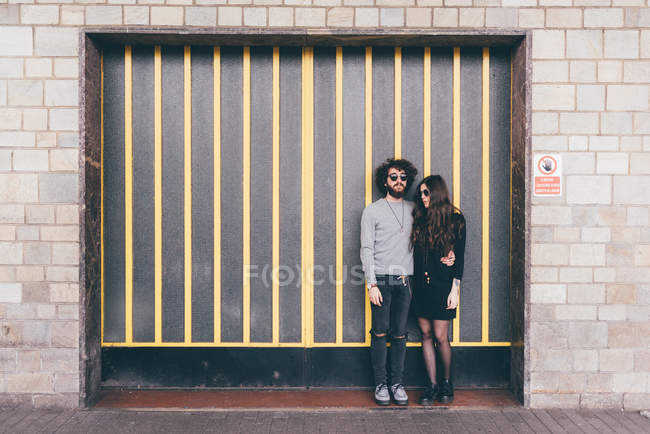 Ritratto di giovane uomo e donna, in piedi insieme al riparo in strada — Foto stock