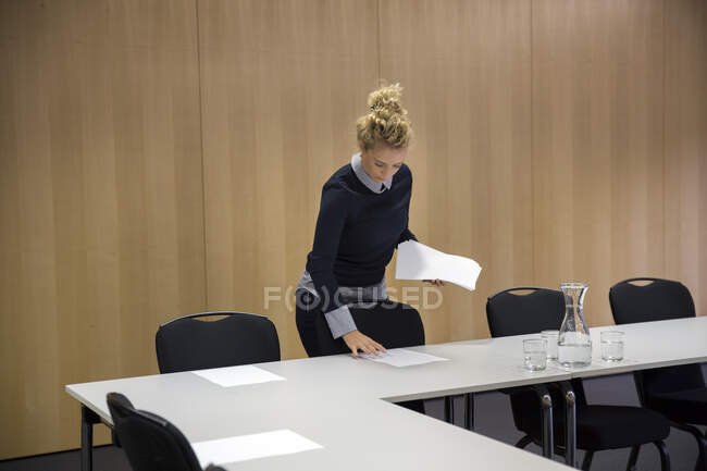 Woman laying out paperwork in conference room — Stock Photo