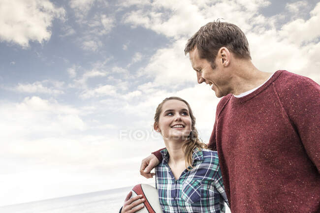 Padre e hija caminando juntos por la playa - foto de stock
