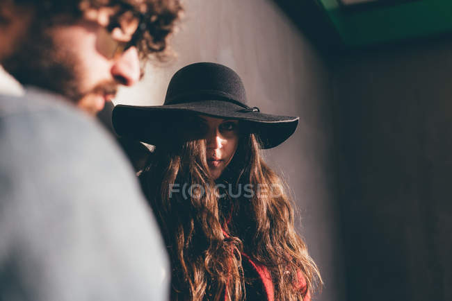 Молодая пара, стоящая на улице, задумчивое выражение лица, низкий угол обзора — стоковое фото