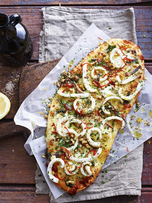Tintenfisch Aglio Olio Pizza auf Servierbrett, Blick über den Kopf — Stockfoto