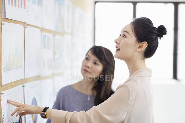 Colleagues working with colour charts and graphs — Stock Photo