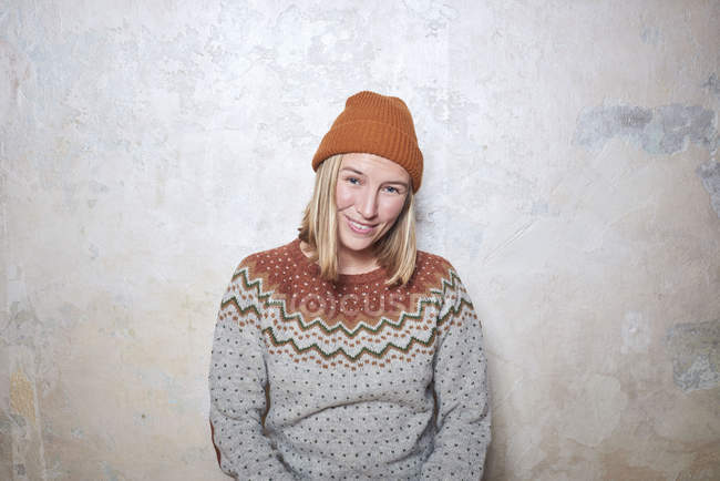 Portrait of woman wearing jumper and knitted hat, smiling — Stock Photo