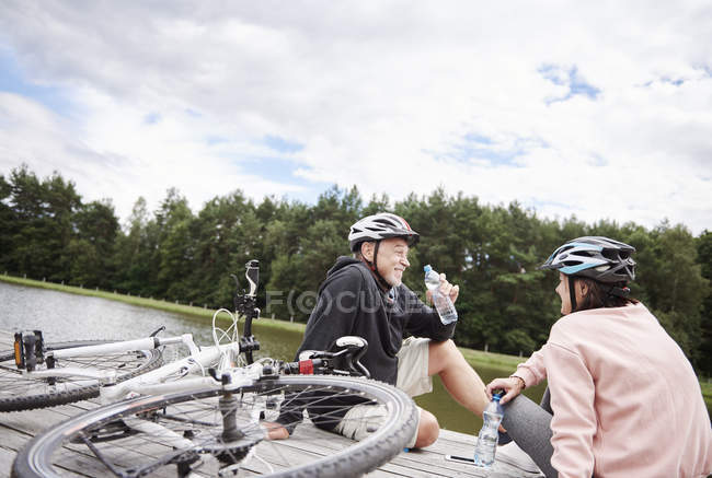 Älteres Paar mit Fahrrädern entspannt am Steg — Stockfoto