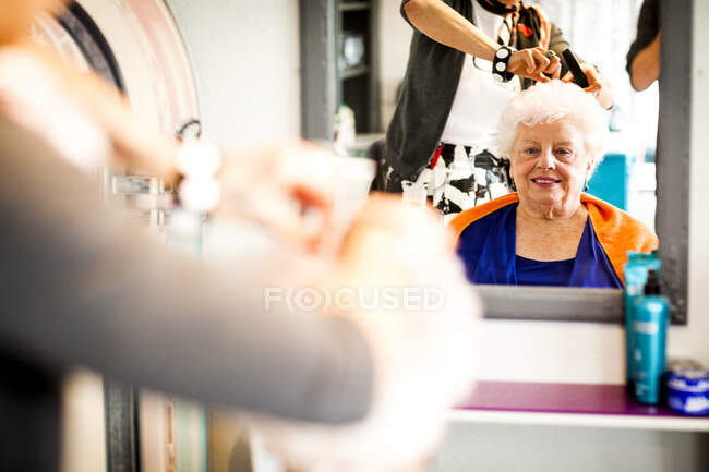 Frau arbeitet in skurrilem Friseursalon — Stockfoto