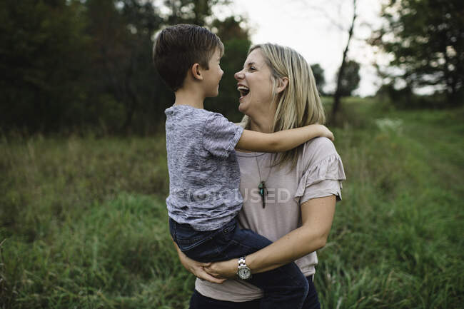 Madre e hijo riendo y disfrutando al aire libre - foto de stock