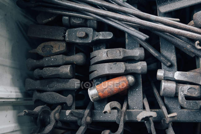 Overhead view of blacksmith tongs and hammers in workshop — Stock Photo