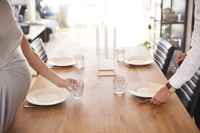 Обрезанный снимок беременной пары, лежащей за обеденным столом — стоковое фото