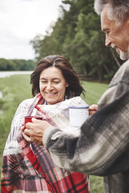 Älteres Paar hält Heißgetränke in ländlicher Umgebung — Stockfoto