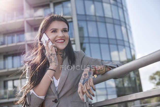 Молода бізнес-леді робить дзвінок на відкритому повітрі — стокове фото