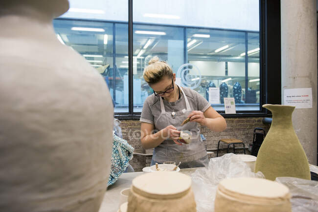 Женщина в художественной студии остекление керамики — стоковое фото