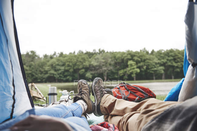 Casal maduro em botas de caminhada relaxante na barraca — Fotografia de Stock