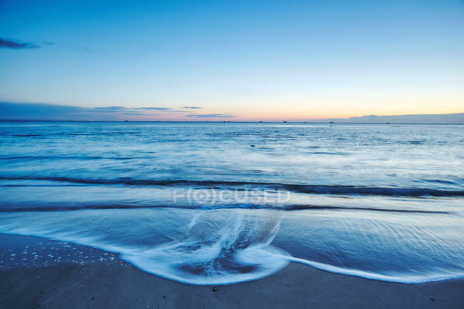 Lapping ondas na praia ao pôr do sol, Odessa, Oblast de Odessa, Ucrânia, Europa — Fotografia de Stock