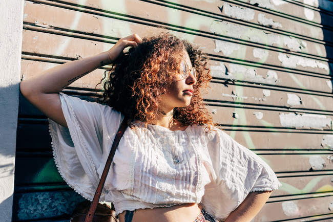 Молода жінка позує проти ролетних вікон — стокове фото
