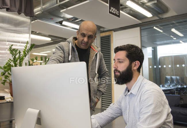 Колеги в офісі дивляться на монітор комп'ютера — стокове фото