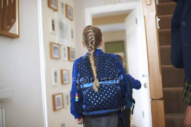 Rear view of schoolgirl in uniform in hallway — Stock Photo