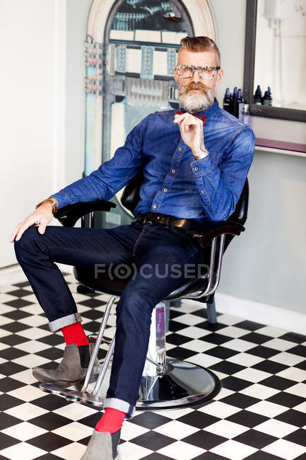 Barbeiro na cadeira no salão de cabeleireiro peculiar — Fotografia de Stock