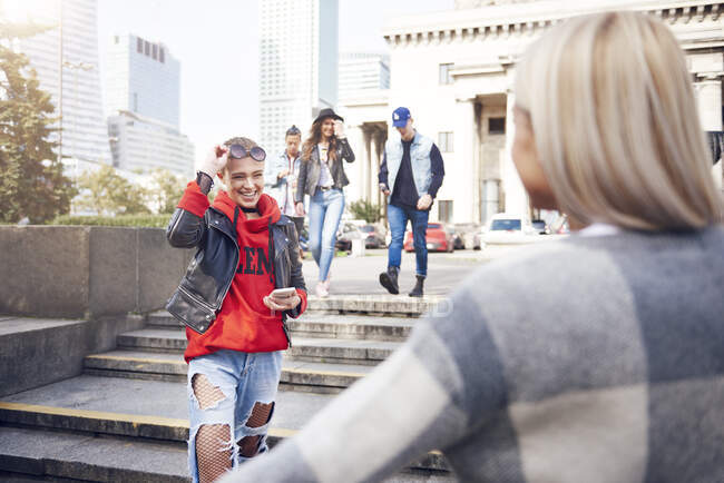Two young female friends greeting each other in city — Stock Photo